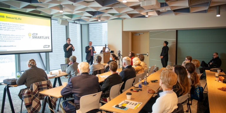 A group of people in a conference room watching a presentation.