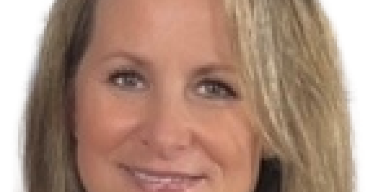 A professional headshot of Susie smiling at the camera.