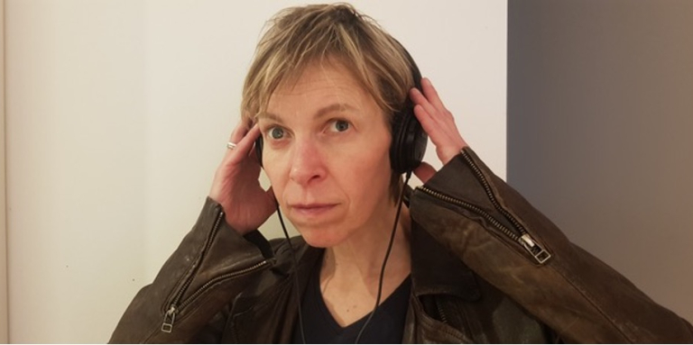 an image of Alex with earphones on smiling
