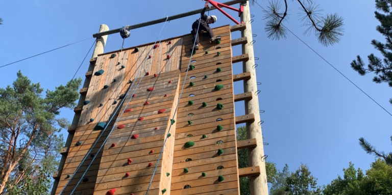 Bev Dean climbing the rock wall at Lake Joe