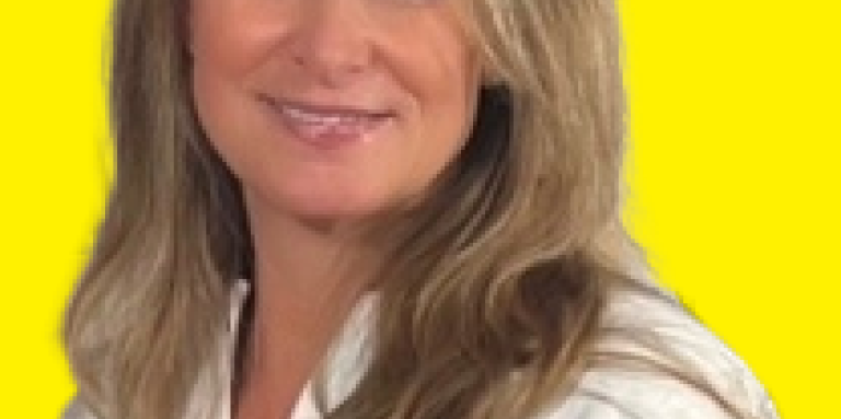 A professional headshot of Susie smiling at the camera.