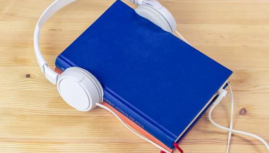 a blue book with headphones resting on top. 
