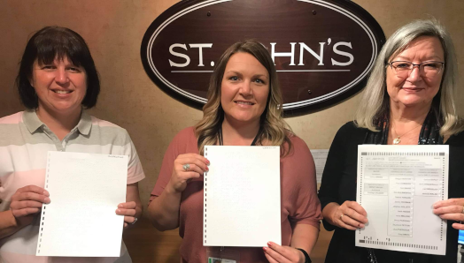Kim Hart CNIB, Trisha Rose, City of St John’s Elections Coordinator and Debbie Ryan, CNIB, holding the first braille ballot being used in the municipal 2021 election.