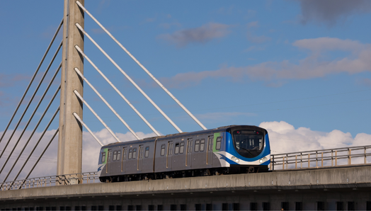 A Skytrain passing across a bridge in the blue Vancouver sky.