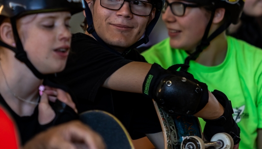  Skateboarders smiling wearing their helmets.