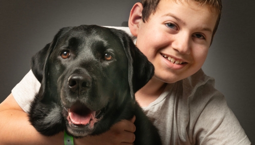 An image of Ollie smiling with his arms wrapped around Hope